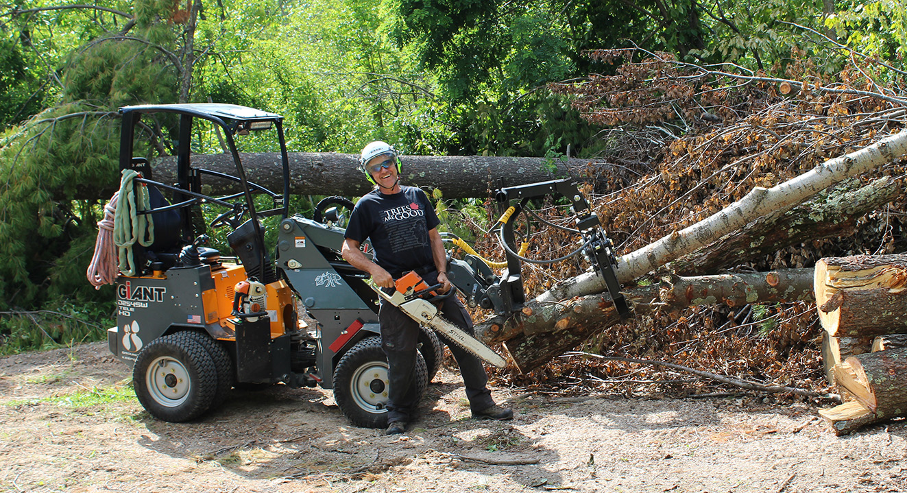 Dave standing next to his G254T / G1200 mini loader with all the extra features installed